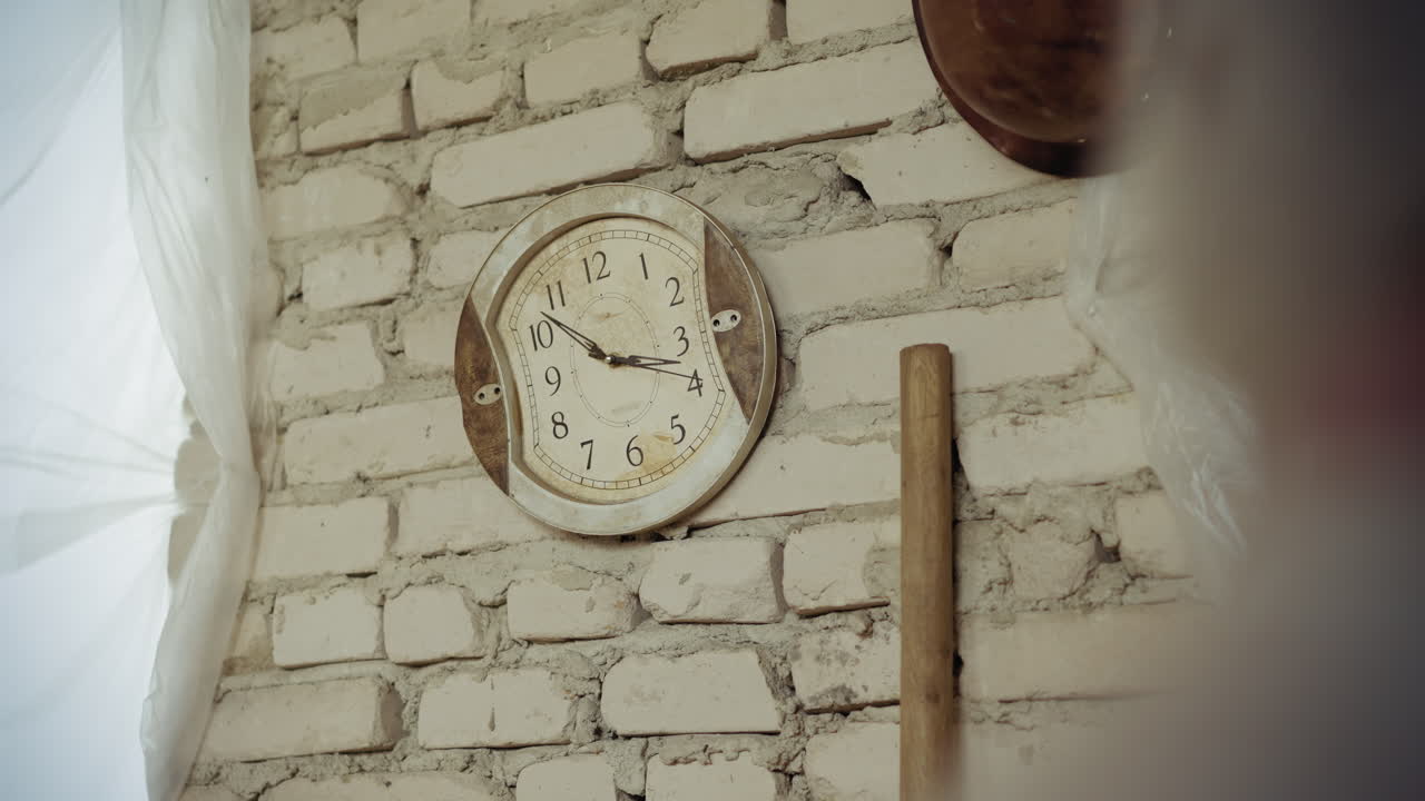 Old warped analog clock with distorted face hangs on white brick wall, ticking steadily as time passes, vintage style evokes surreal feeling of time slipping in rustic damaged indoor setting