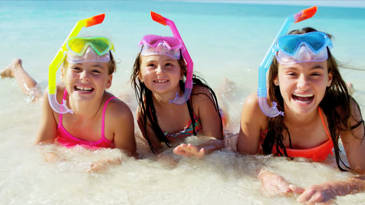 Portrait of Caucasian girls on beach going snorkeling