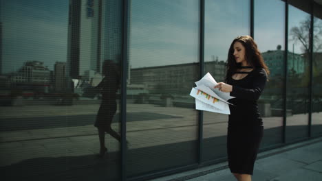 Woman-smiling-with-documents-in-hand.-Woman-throwing-papers-in-air-at-street