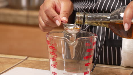 making a homemade marinade with a base of sherry - measuring out a tablespoon into a mixing cup