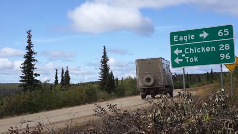 static shot of a large off road camper van driving down a dirt road en route to eagle, alaska