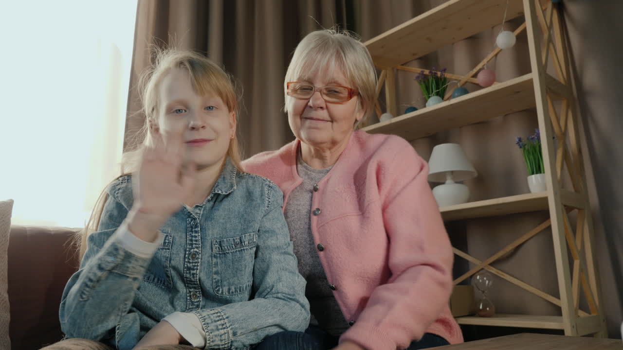화상 통화 중 할머니와 손녀가 카메라에 말합니다.