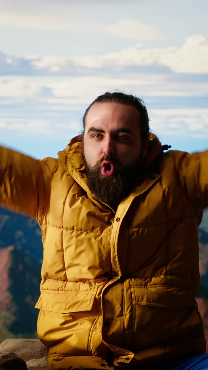 Expressive Man in Yellow Puffer Jacket Posing in Mountain Landscape