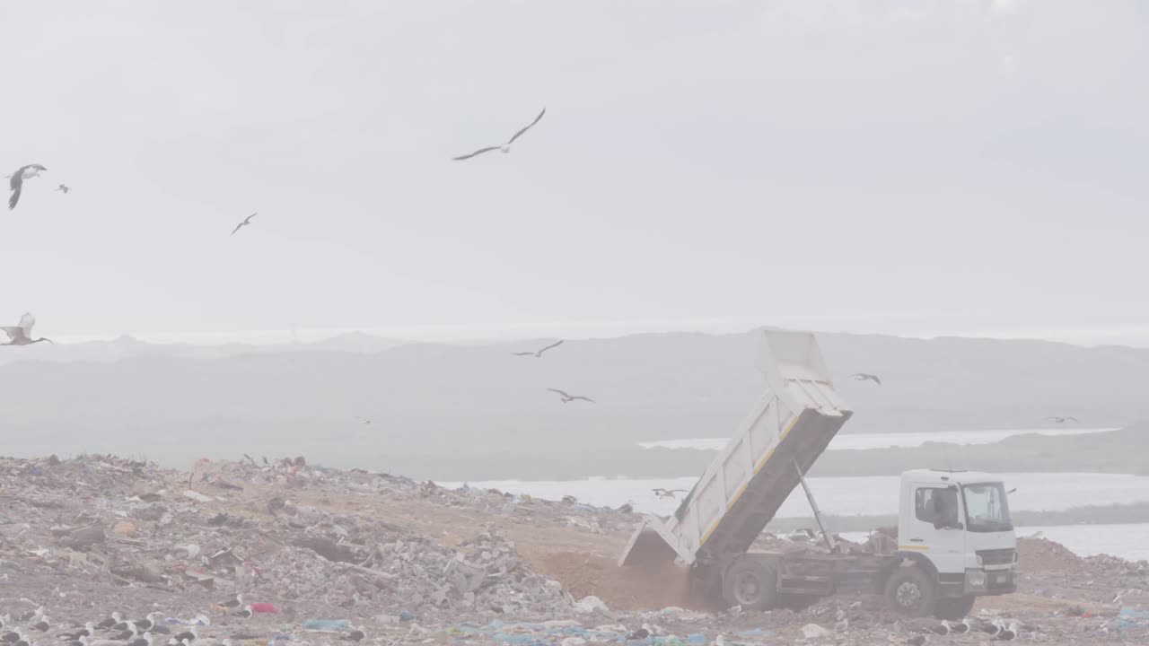 vehículos que limpian la basura apilada en un vertedero lleno de basura