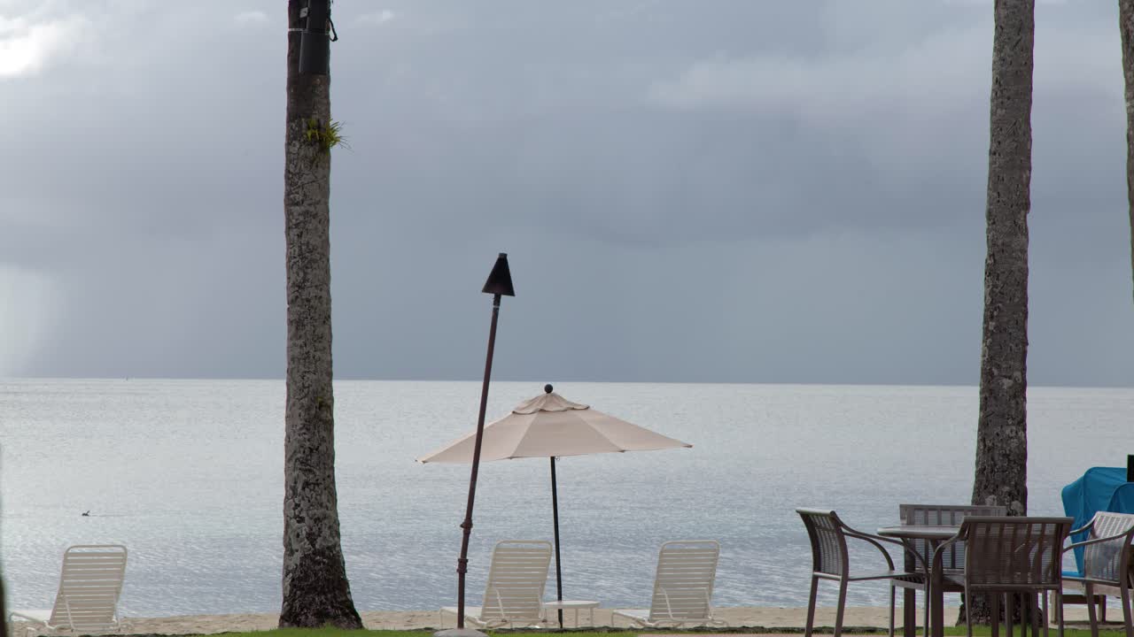 Ampia inquadratura statica di un tranquillo resort tropicale sulla spiaggia sotto cieli nuvolosi a Palau