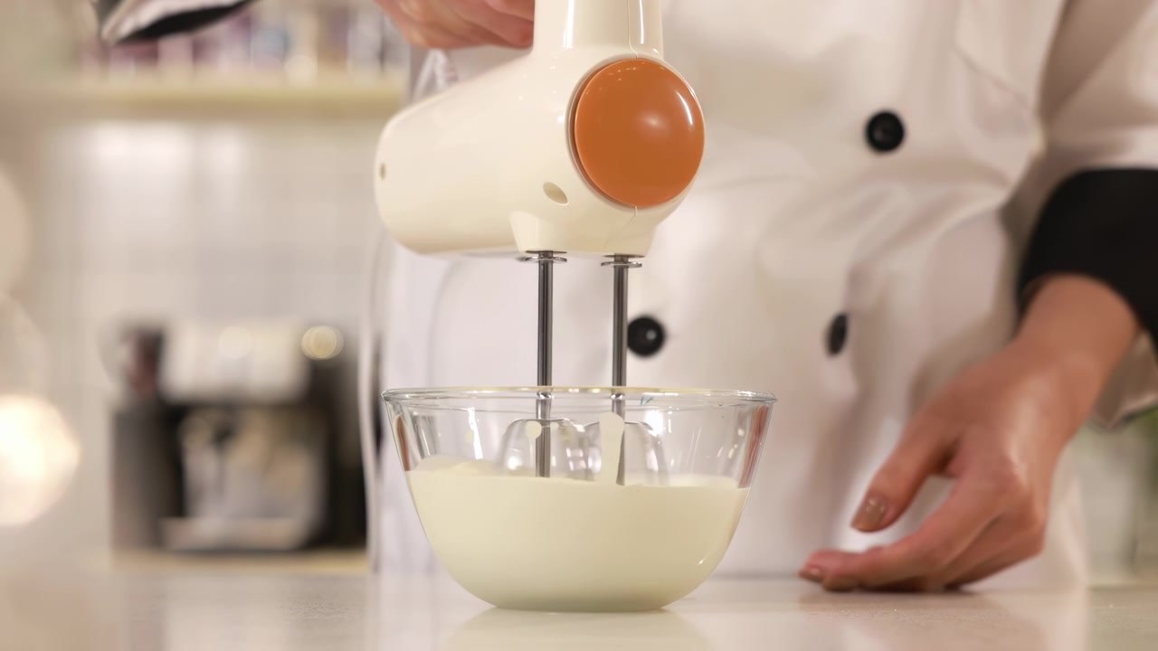 Master pastry chef hand whipping raw egg whites with sprinkles sugar with butter in white bowl with electric mixer beats for delicious birthday bakery order, ideal baking, confectionery, culinary food