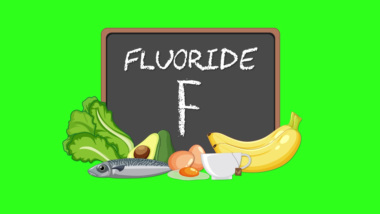 Elemento animato di fluoruro su lavagna circondato da alimenti assortiti e salutari su sfondo verde brillante