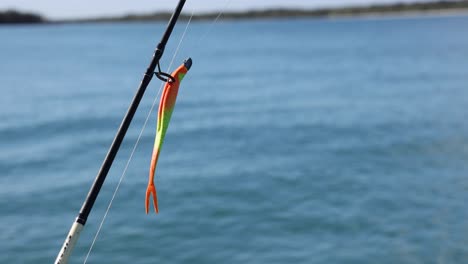 fishing rod with lure over calm water