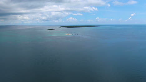 Drone-shot-tropical-sand-island-full-of-people-and-boats