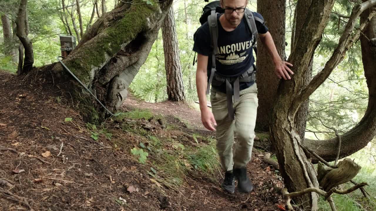 un hombre caminando por un bosque muy verde en un día nublado en eslovenia ubicado cerca del pueblo de gozd martuljek-5