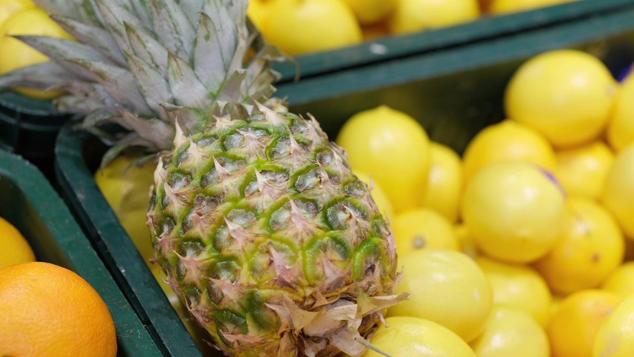 Fresh pineapple and lemons at grocery store produce section