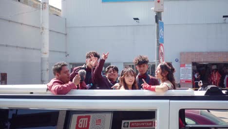 teenagers celebrate in limousine during city parade