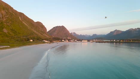 Aerial-view-of-Ramberg-beach-bay-with-mountains-landscape-in-the-background