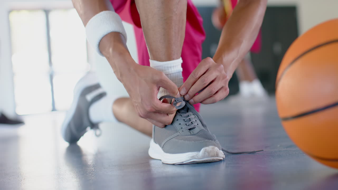 Atleta che si allaccia le scarpe in un campo al coperto