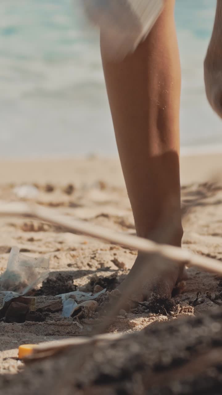 Hands of volunteer or environmental activist collecting garbage from beach