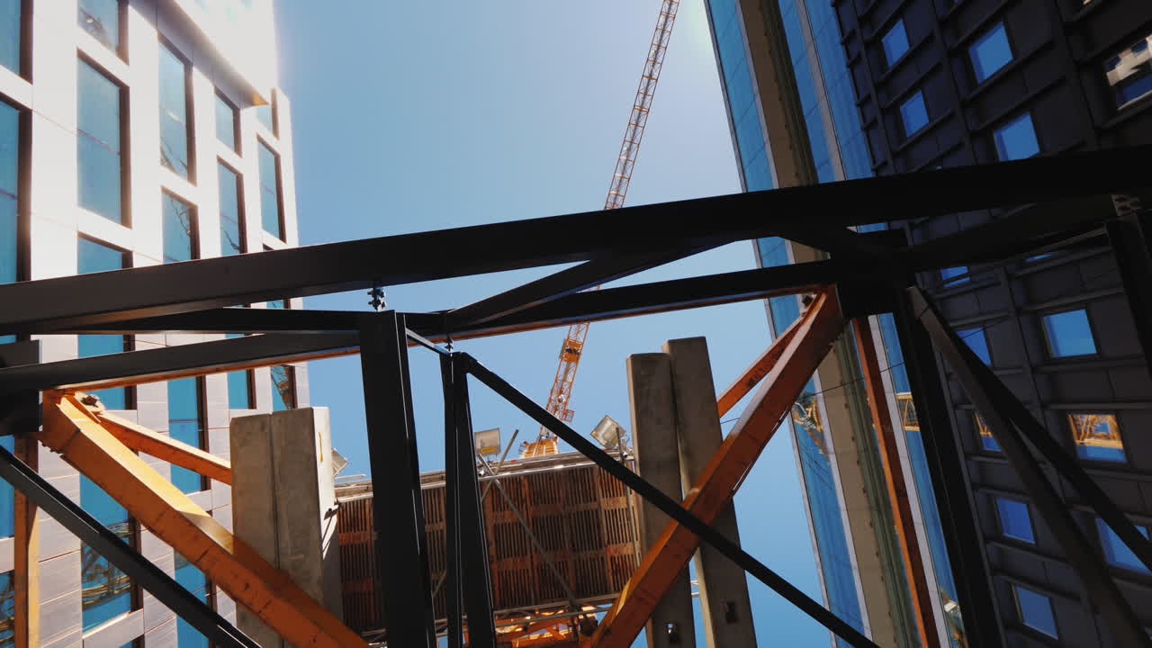 A Huge Construction Crane Near Office Buildings With Glass Facades City Building Steadicam Shot