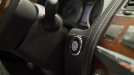 persona que presiona el botón de arranque del coche