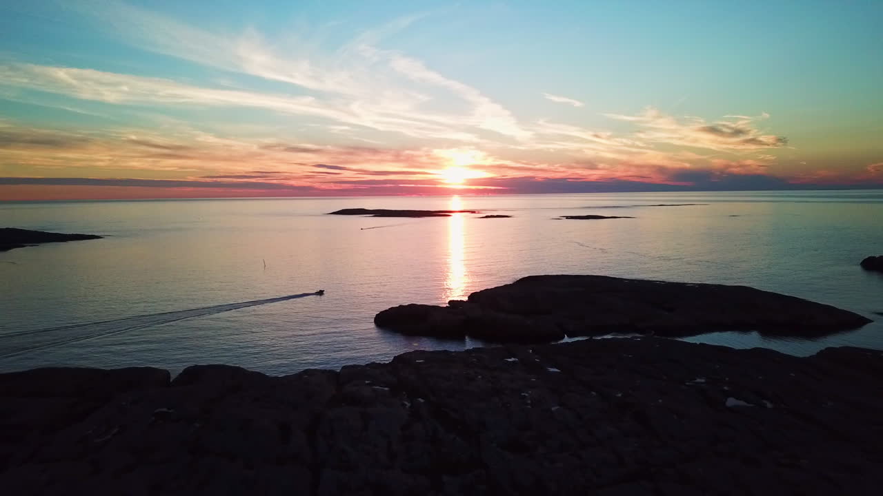 일몰과 모터보트를 향해 절벽 위로 날아가는 드론