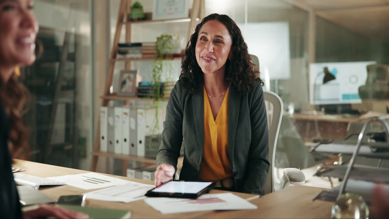 dos mujeres de negocios se dan la mano en una oficina