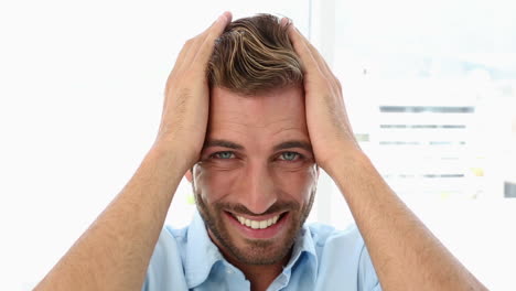 un hombre de negocios con dolor de cabeza sacudiendo la cabeza.