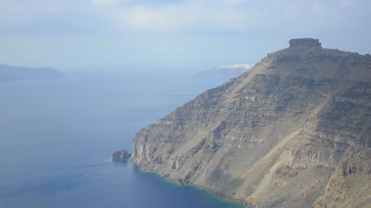 las sombras de las nubes pasando sobre un área árida de la caldera de santorini en grecia