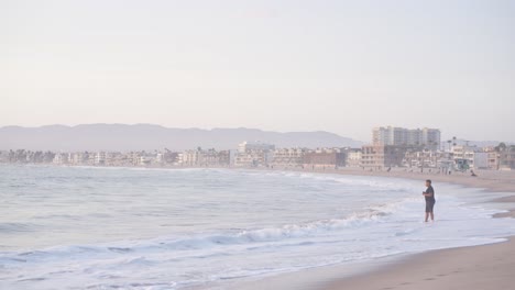 one man listing to the music and walk on the beach alone, venice beach of los angeles usa