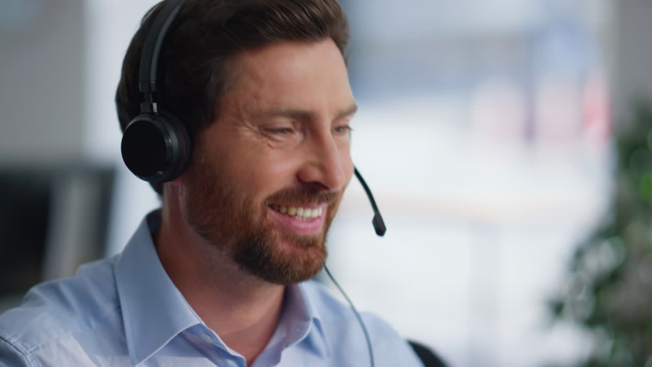 Spesialist på portrettsalg som ringer en klient på et telemarketingskontor. Smilende mann