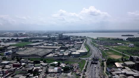 aerial view of a industrial area in sunny douala city, cameroon - tracking, drone shot