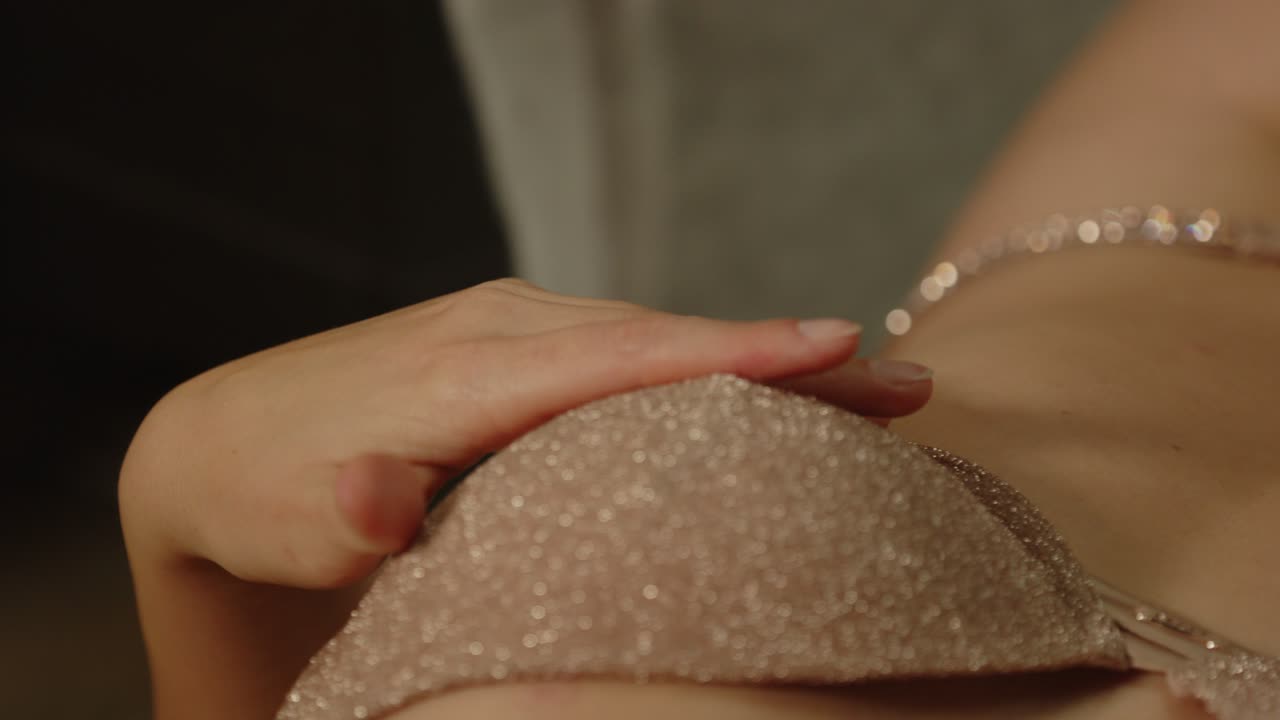 Sensual close up of a hand caressing the brassier of a woman dressed in sexy lingerie