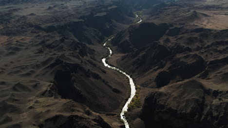 Drone-shot-tilting-over-a-river-gorge-in-the-mountains-of-sunny-Kazakhstan