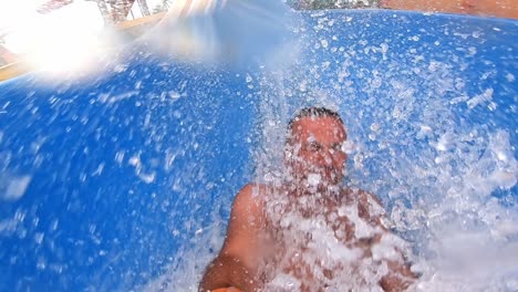 man having fun on a water slide in a water park