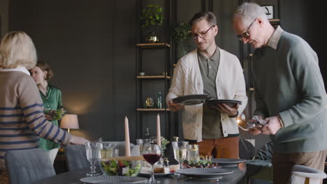 familia feliz en una sala de estar moderna preparando la mesa de comedor juntos