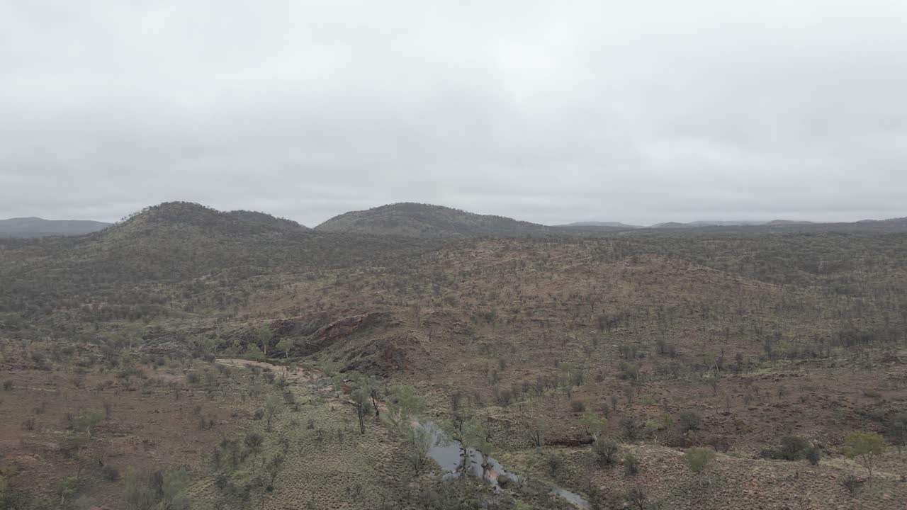 volando sobre un paisaje semiárido en la niebla en el parque nacional west macdonnell