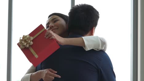 romantic couple giving gift to lover at restaurant