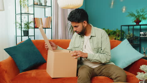 Angry-dissatisfied-shopper-Indian-man-unpacking-parcel-feeling-upset,-confused,-wrong-delivery