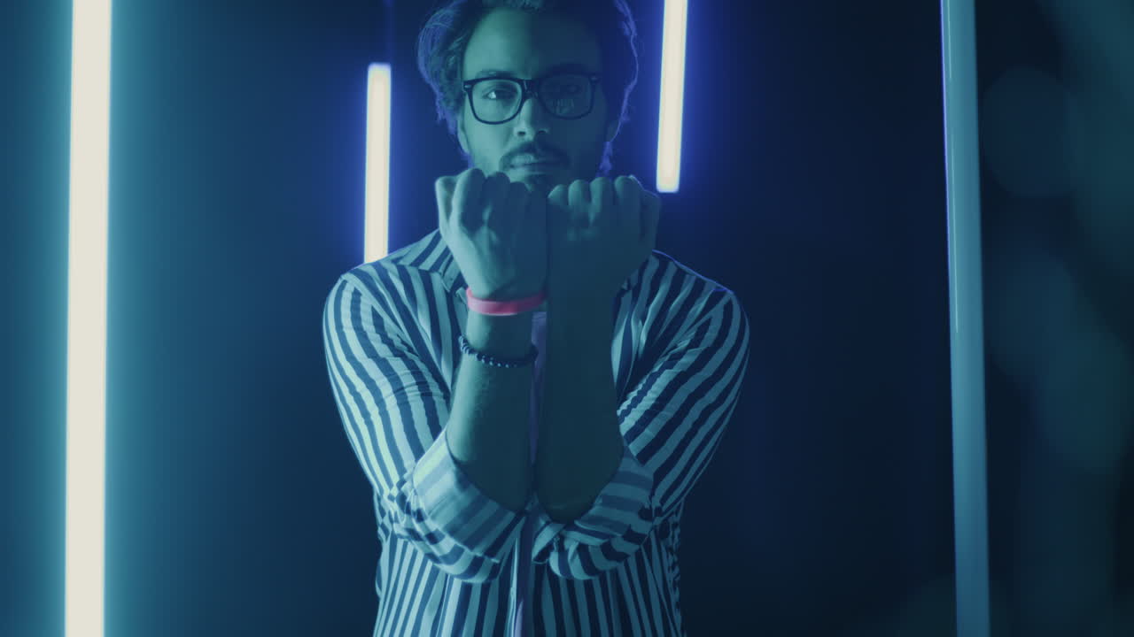Man in Striped Shirt Under Neon Lights
