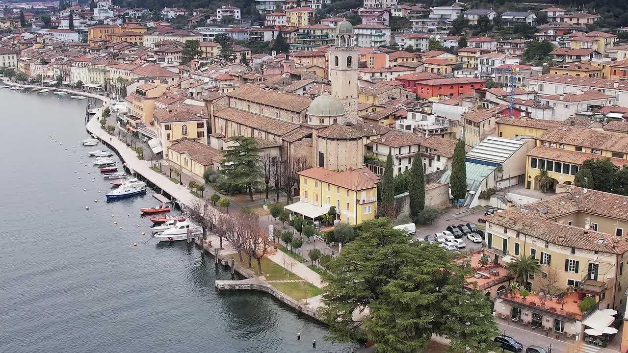 Vista de uma cidade alpina na Itália perto do lago com barcos e edifícios