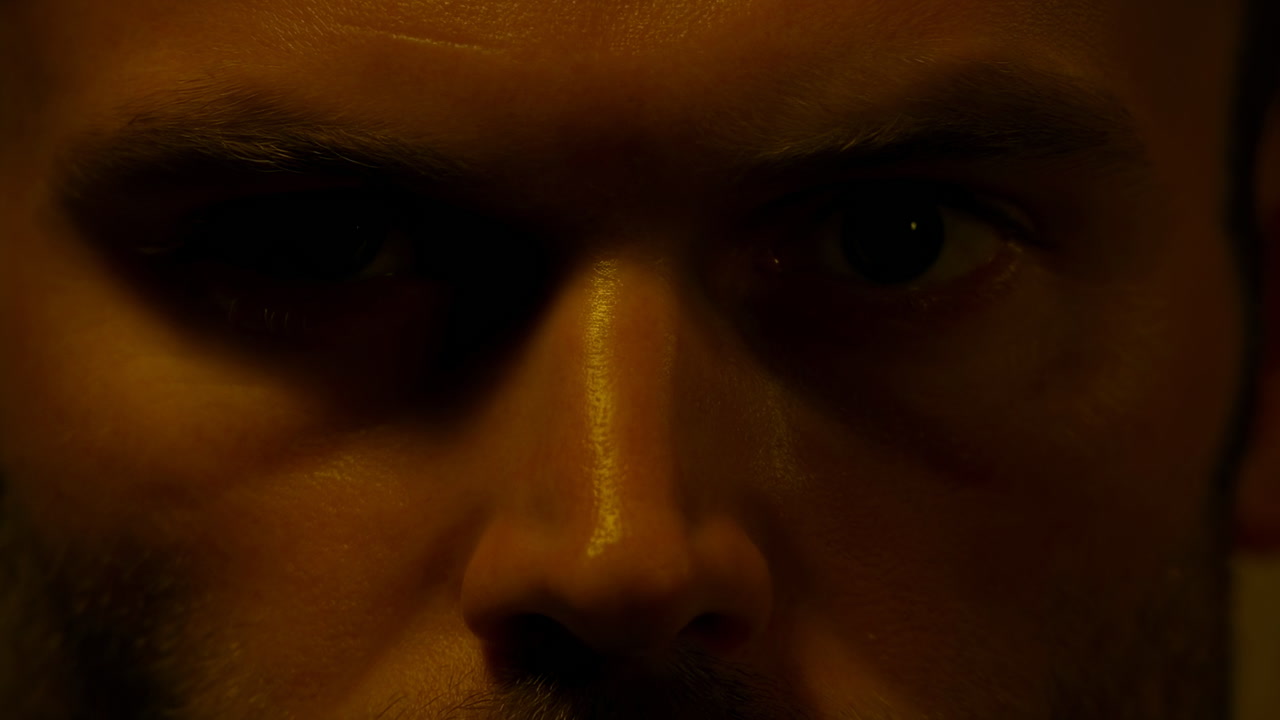 Closeup Caucasian Detective Intense Gaze, Shadowed Face In Warm Lowkey Lighting, Furrowed Brow, Stubble,