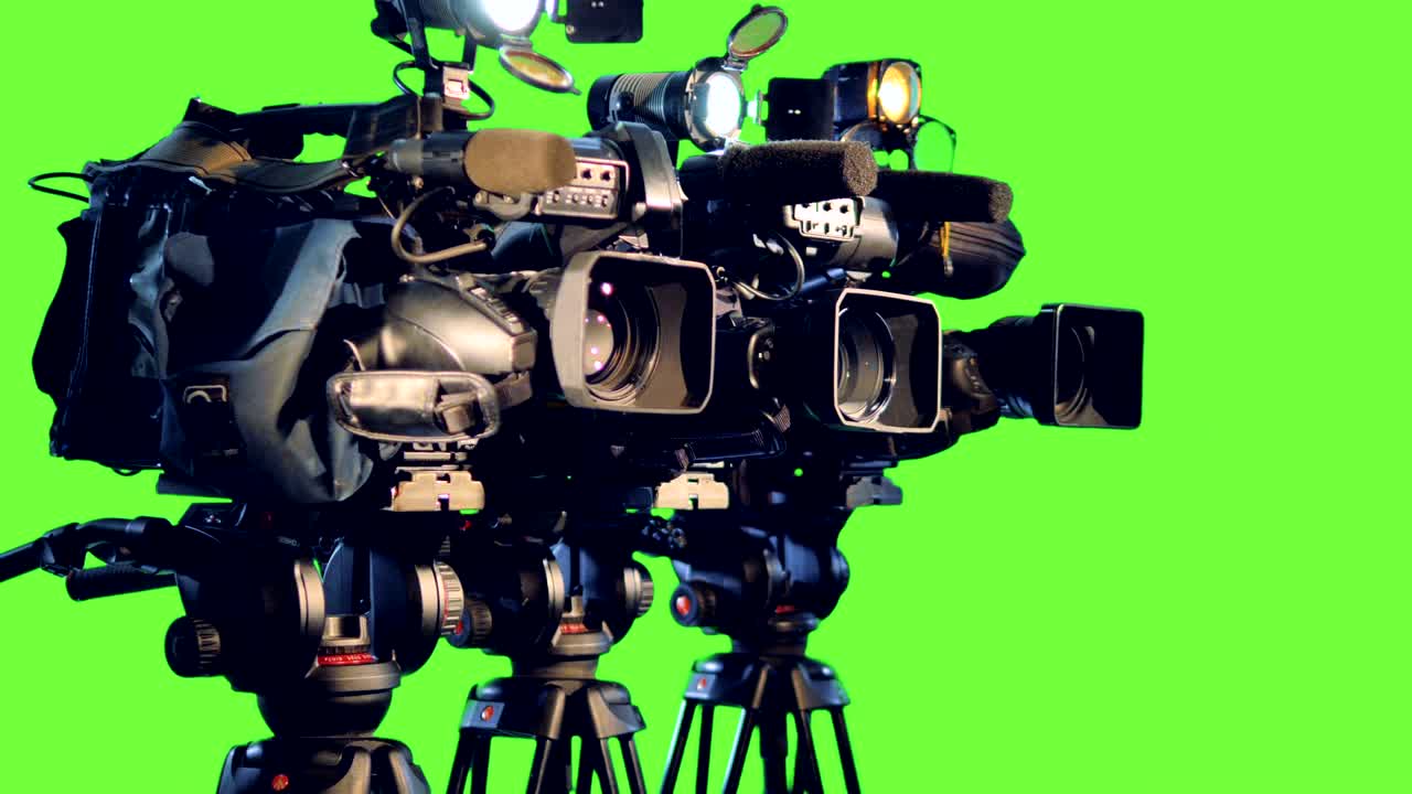 A side view on three professional video cameras.