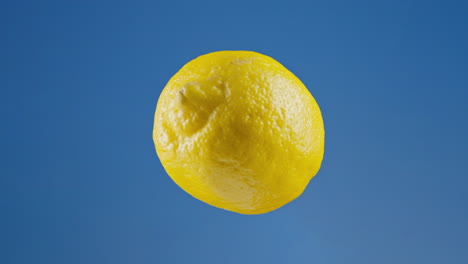 Ripe-lemon-rotating-on-blue-background