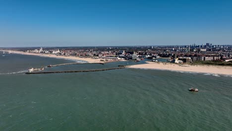 Scheveningen-beach-aerial-view-of-ship-entering-Vissershaven,-The-Hague