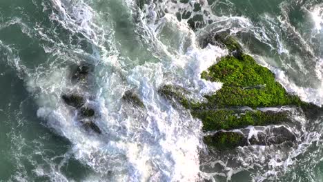 aerial photos of waves hitting reefs and sparking waves