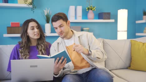 una pareja feliz y linda trabajando desde casa compartiendo ideas entre sí, haciendo una lluvia de ideas.