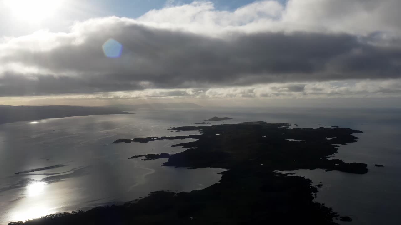 AERIAL - Silhouette of the Isle of Gigha at sunrise, Kintyre, Scotland, forward