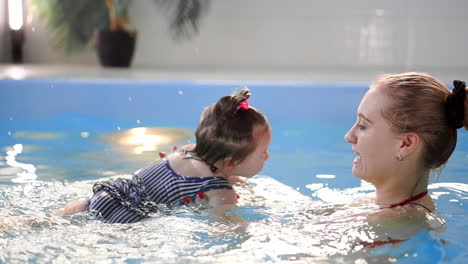 happy smiling toddler is jumping and diving under the water in the swimming pool. an underwater shot. slowmotion