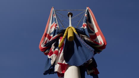 union jack flags on pole against the blue sky in london, uk