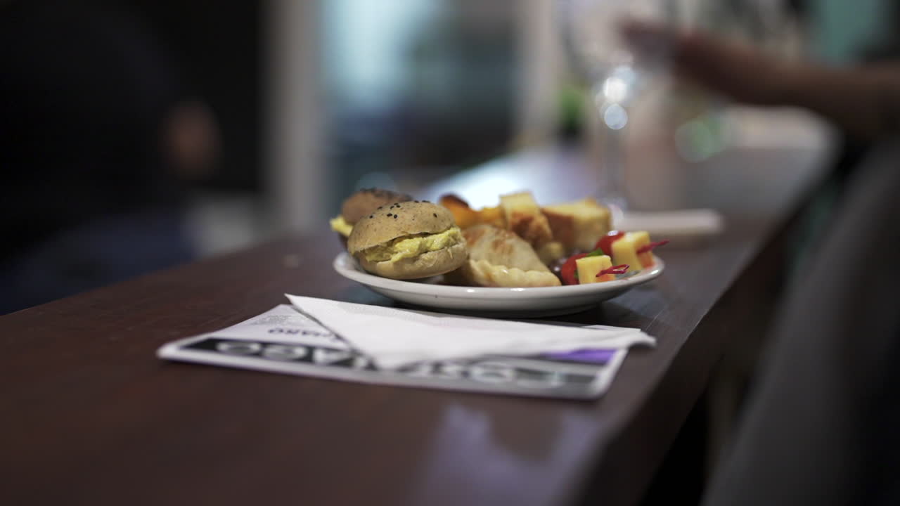 Close-up view of a plate with empanadas and delicious sandwiches as appetizer for guests on a service counter.
