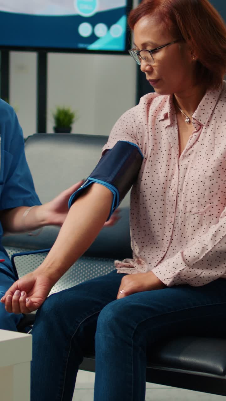 Vertical video: Specialist checking hypertension on tonometer in waiting room