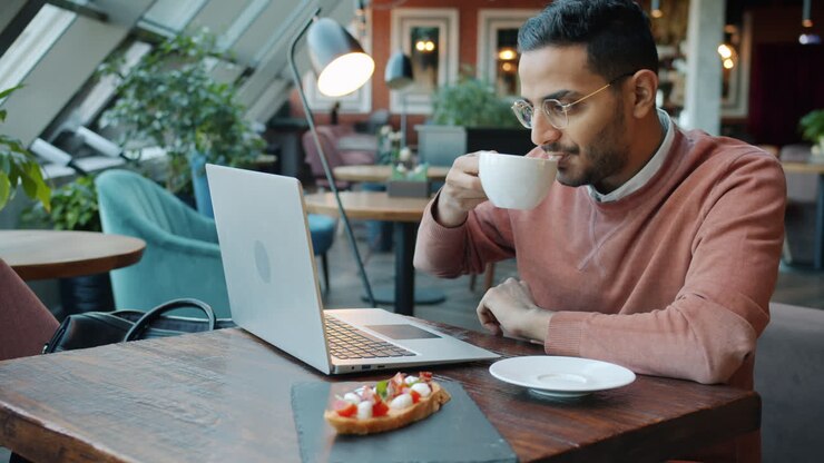 Man working on laptop in a cafe