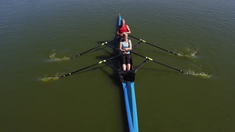 senior caucasian man and woman rowing boat on a river